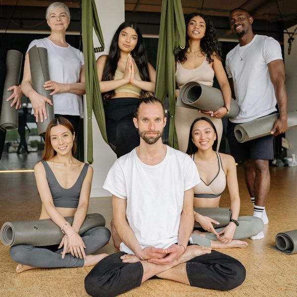 Diverse group of people sitting peacefully in a yoga studio.